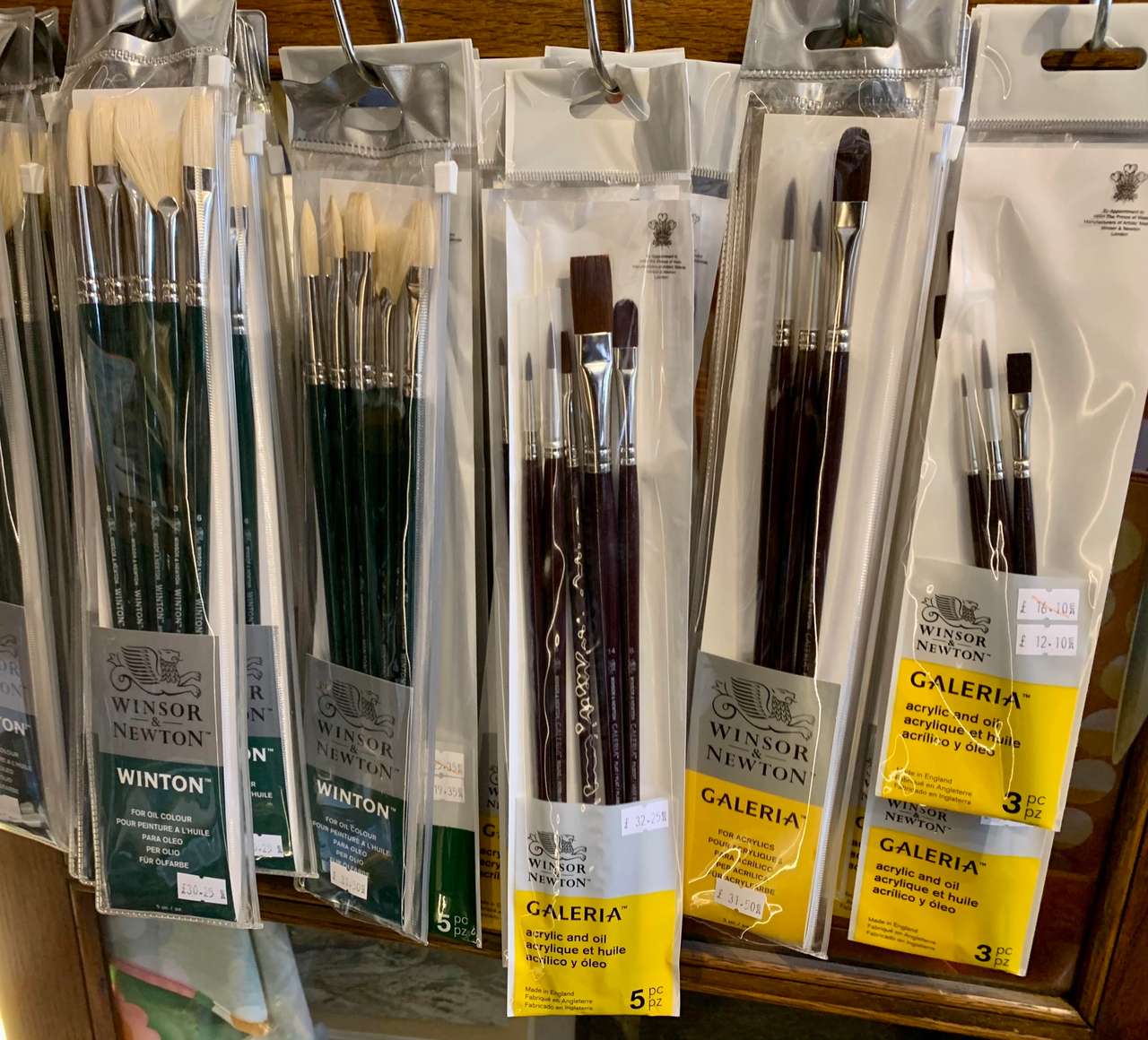 Packs of Winsor & Newton Winton and Galeria brushes hanging on hooks